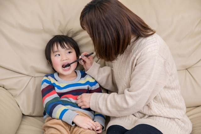 子供の歯を磨く母親